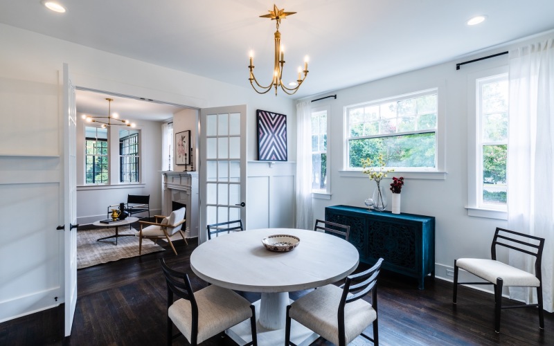 table chairs windows and a chandelier in a room