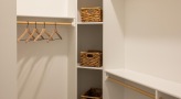 a closet with baskets and hangers
