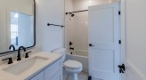 a bathroom with a sink, toilet and mirror
