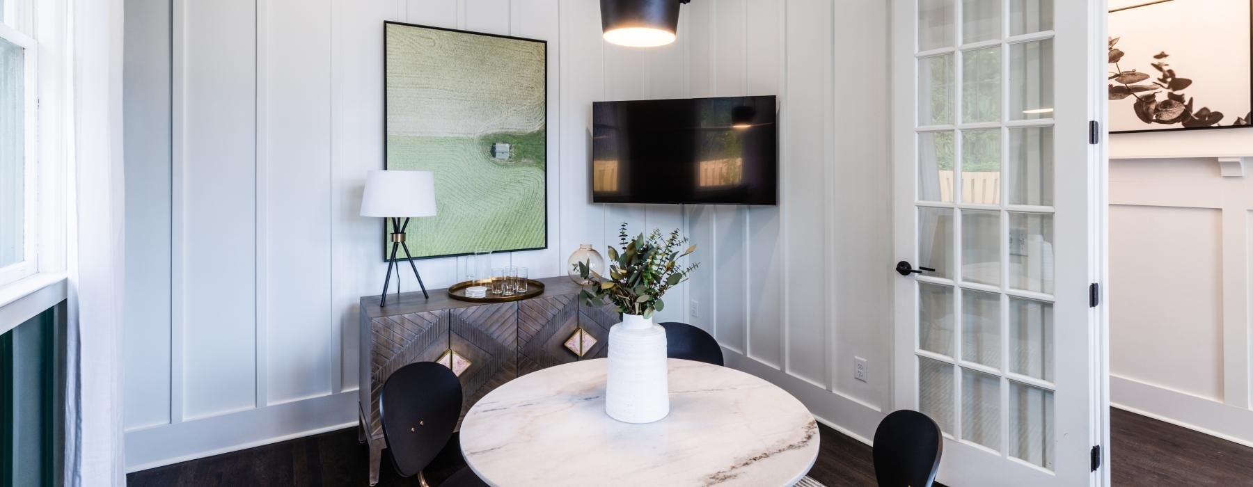 a room with a tv, table and chairs