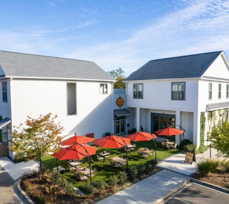 a white building with red umbrellas